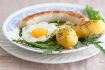 Bratwurst und Spiegelei auf Spinat und Karoffel