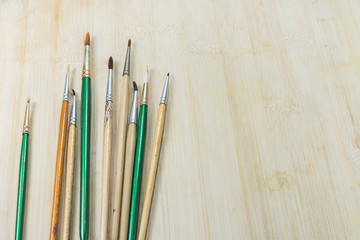 Obraz premium Used artist paintbrushes on wood background