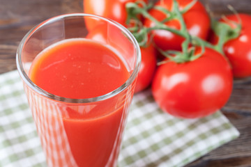 tomato juice and fresh tomatoes on wooden table