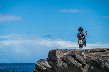 Traditional bagpiper in the scottish highlands near Pennan - obrazy, fototapety, plakaty