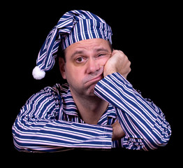 unhappy man in pajamas on a black background