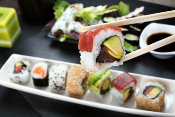 eating sushi roll using chopsticks on the table restaurant