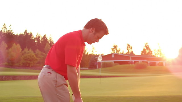 A golfer takes a smooth swing and pitches the ball onto the green