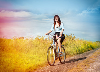 Funny girl with bicycle  in a country road.