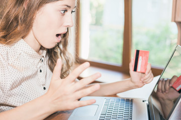 successful woman holding credit card, shopping by laptop