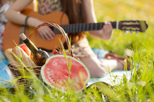 Woman playing guitar on a picnic
