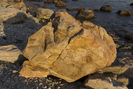 Large boulder on the beach at sunset in Groton, Connecticut.