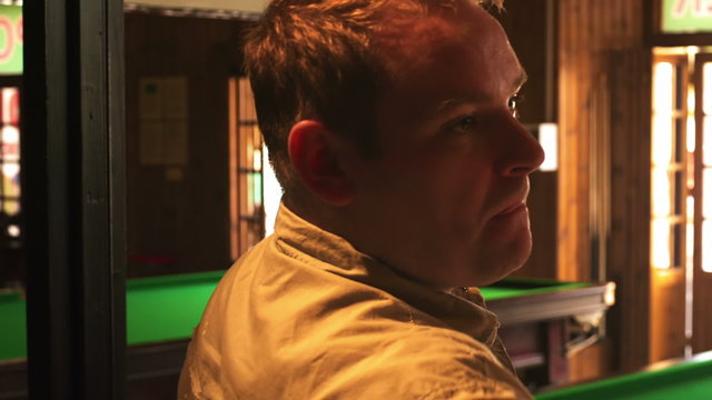 Close up of a man throwing darts at a bar