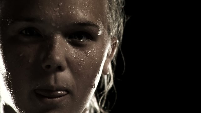 A female athlete breathes heavy and sweats after an intense exercise 