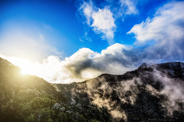 Mountains with clouds and sun with sunlight