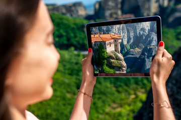 Woman photographing Meteora monastery in Greece