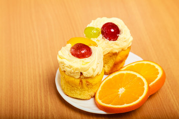 Gourmet cream cake cookie and orange on plate