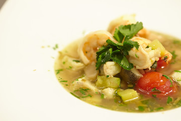 soup with fish, tomatoes, zucchini, herbs