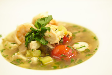 soup with fish, tomatoes, zucchini, herbs