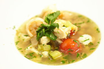 soup with fish, tomatoes, zucchini, herbs