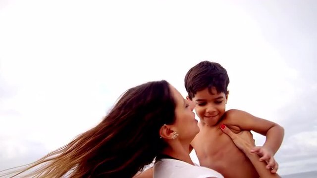 Mother holds her son on a beach in Brazil