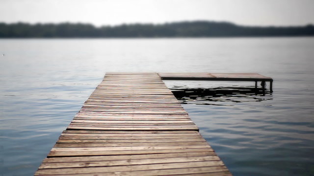 Shot of a wooden dock extending out into the water on a lake