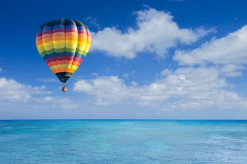 Poster Colorful hot air balloon fly over the blue sea © littlestocker