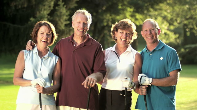 A group of older golfing buddies stand next to each other for a portrait 
