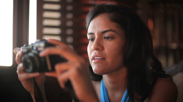 Cute woman looks through the photos she shot