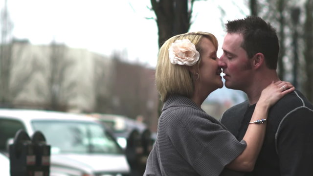 A couple kiss romantically on the street. Aww