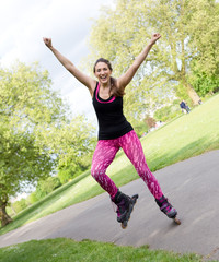 happy young woman with rollerblades in the park