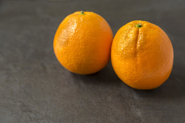 Two oranges on slate background