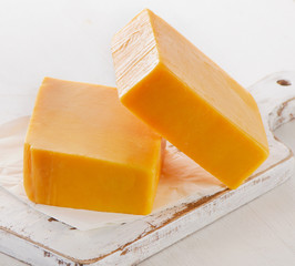 Cheddar Cheese on a white Cutting Board.