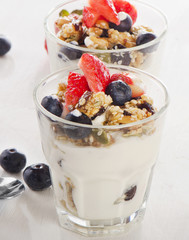 Granola with yogurt and fresh berries in  glass.