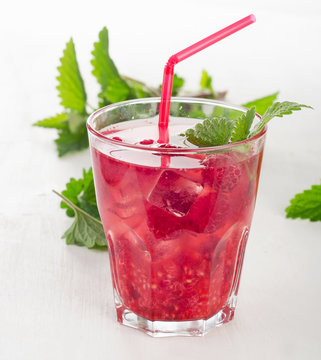 Summer cold drink with raspberries, ice and mint .