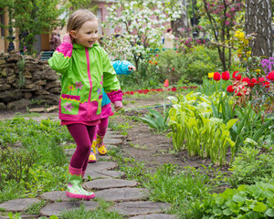 Beautiful little girl in the Park after the rain.