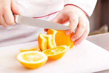chef cutting orange