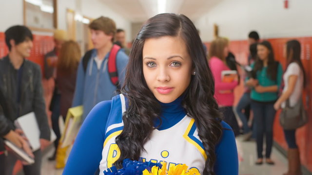 A cheerleader looks into the camera with a straight face