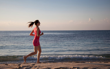 Young woman running along the coast