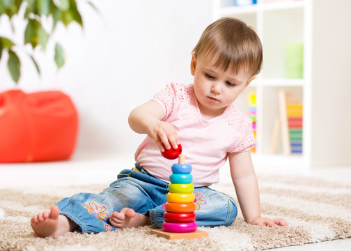 Child girl playing with toy at home