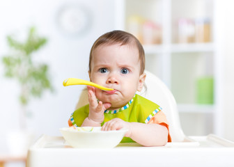 funny baby eating food on kitchen