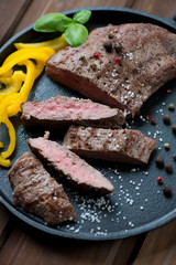 Frying pan with sliced medium grilled barbecue steak, close-up