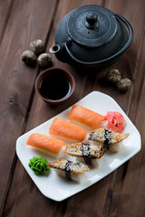 Sushi set on a glass plate with a dipping sauce and teapot