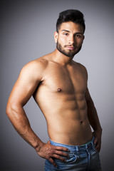 Naklejka premium Hombre latino con torso desnudo y pantalones vaqueros