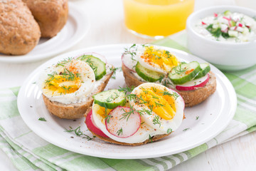 buns with egg and vegetables on plate for breakfast