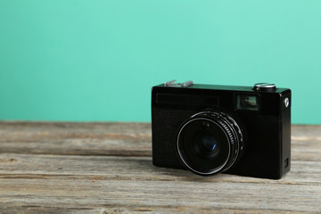 Old retro camera on grey wooden background