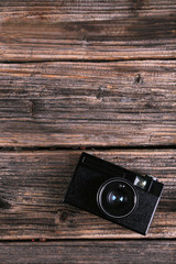 Old retro camera on brown wooden background. Toning