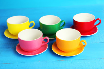 Colorful cups on blue wooden background