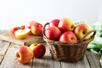 Red apples in basket on grey wooden background