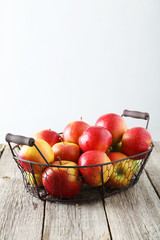 Red apples in basket on grey wooden background
