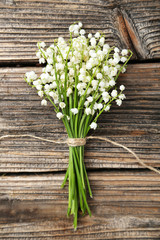 Lily of the Valley on brown wooden background