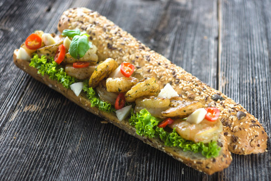 Sandwich with shrimps crispy baguette on a wooden background