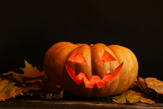 Halloween pumpkin on brown wooden background