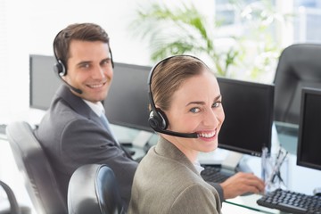 Business people with headsets using computers 