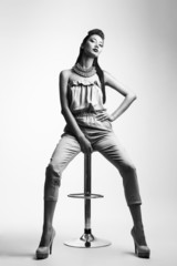 Studio shoot of beauty woman posing on the chair. Black and whit